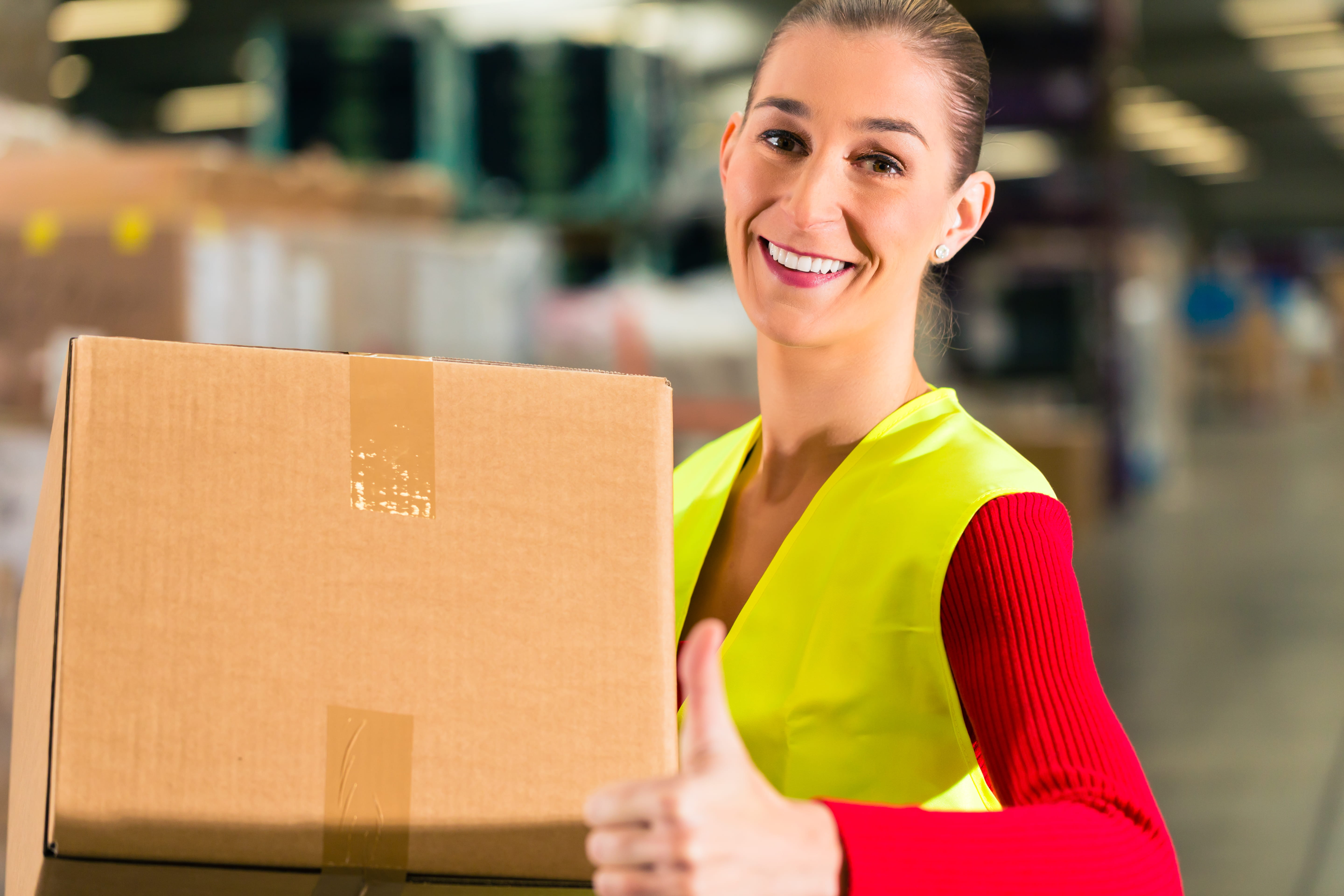 woman in warehouse holding box woman in warehouse holding box