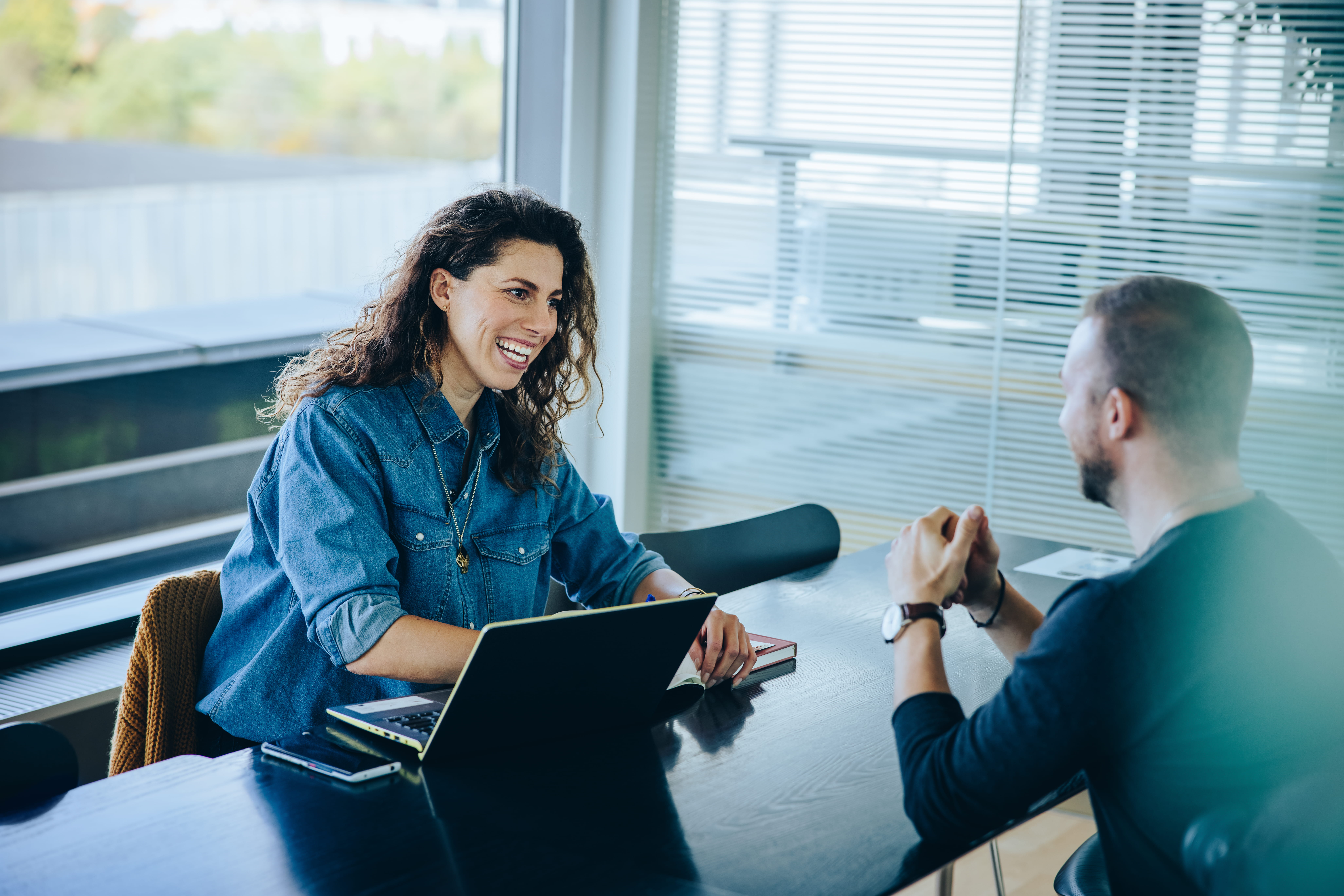 two people having conversation at desk two people having conversation at desk