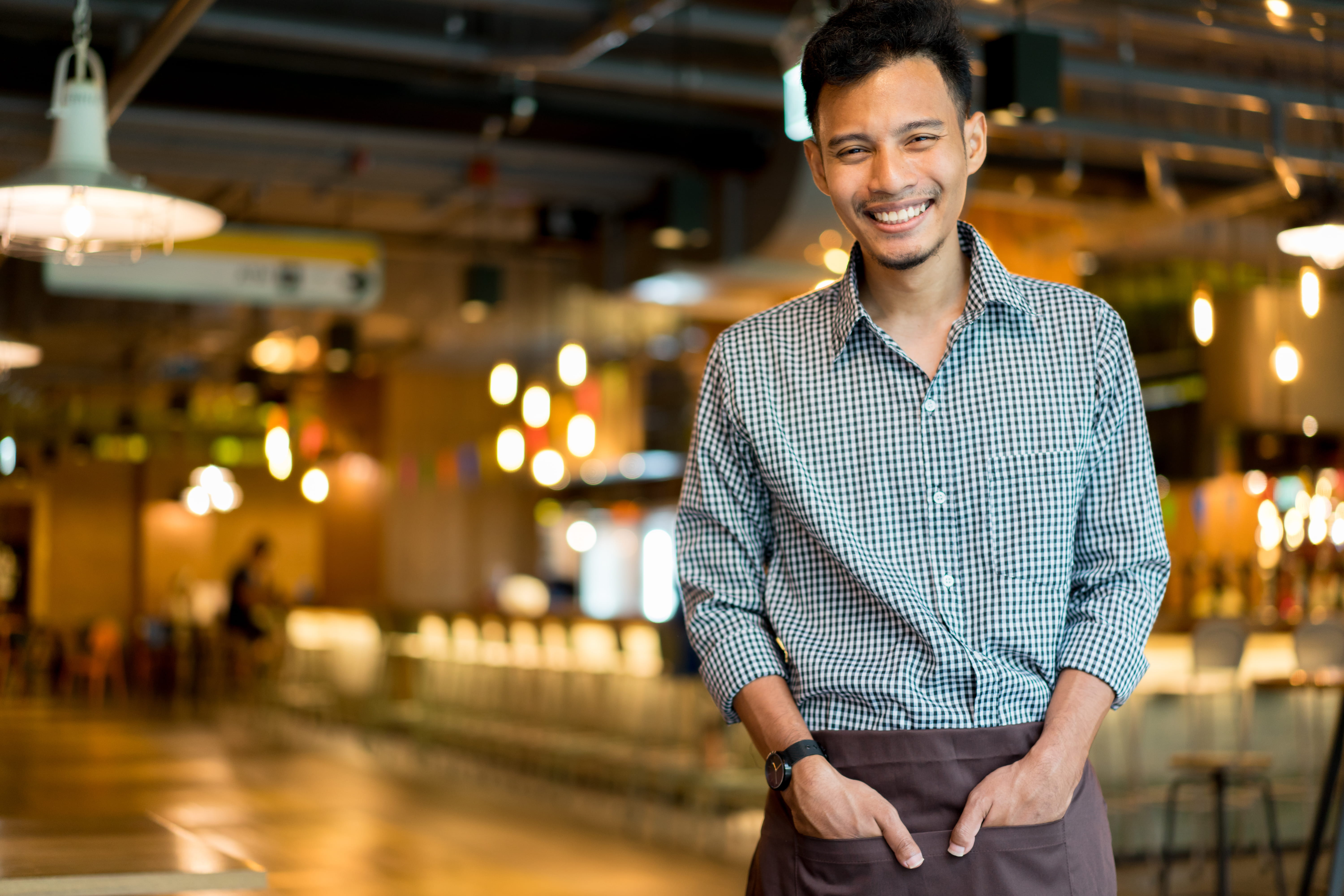 young waiter smiling in restaurant young waiter smiling in restaurant
