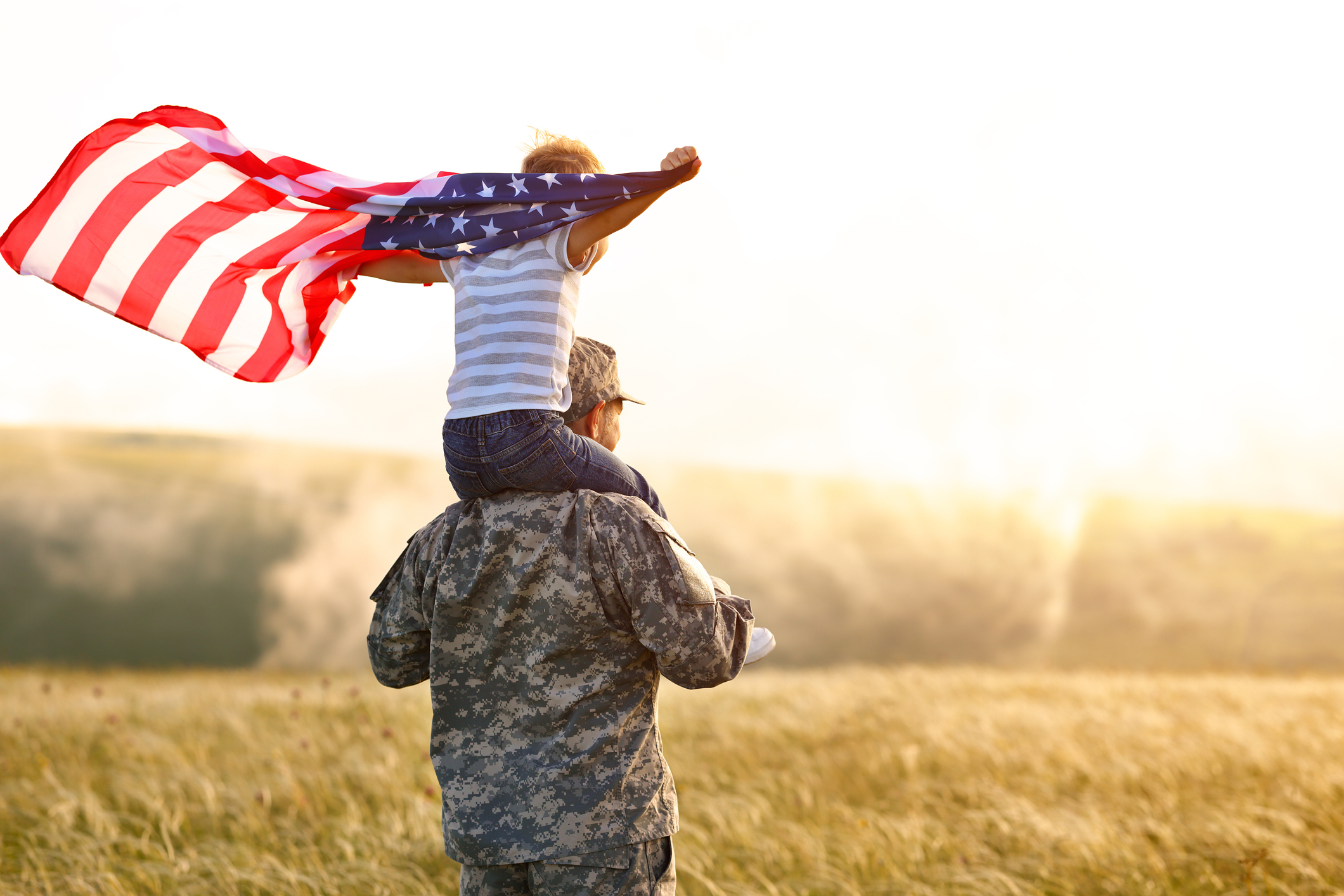 rear view of child on military man's shoulders rear view of child on military man's shoulders